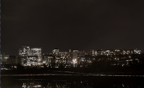Lit office towers of the Rosslyn skyline at night, reflected across dark water